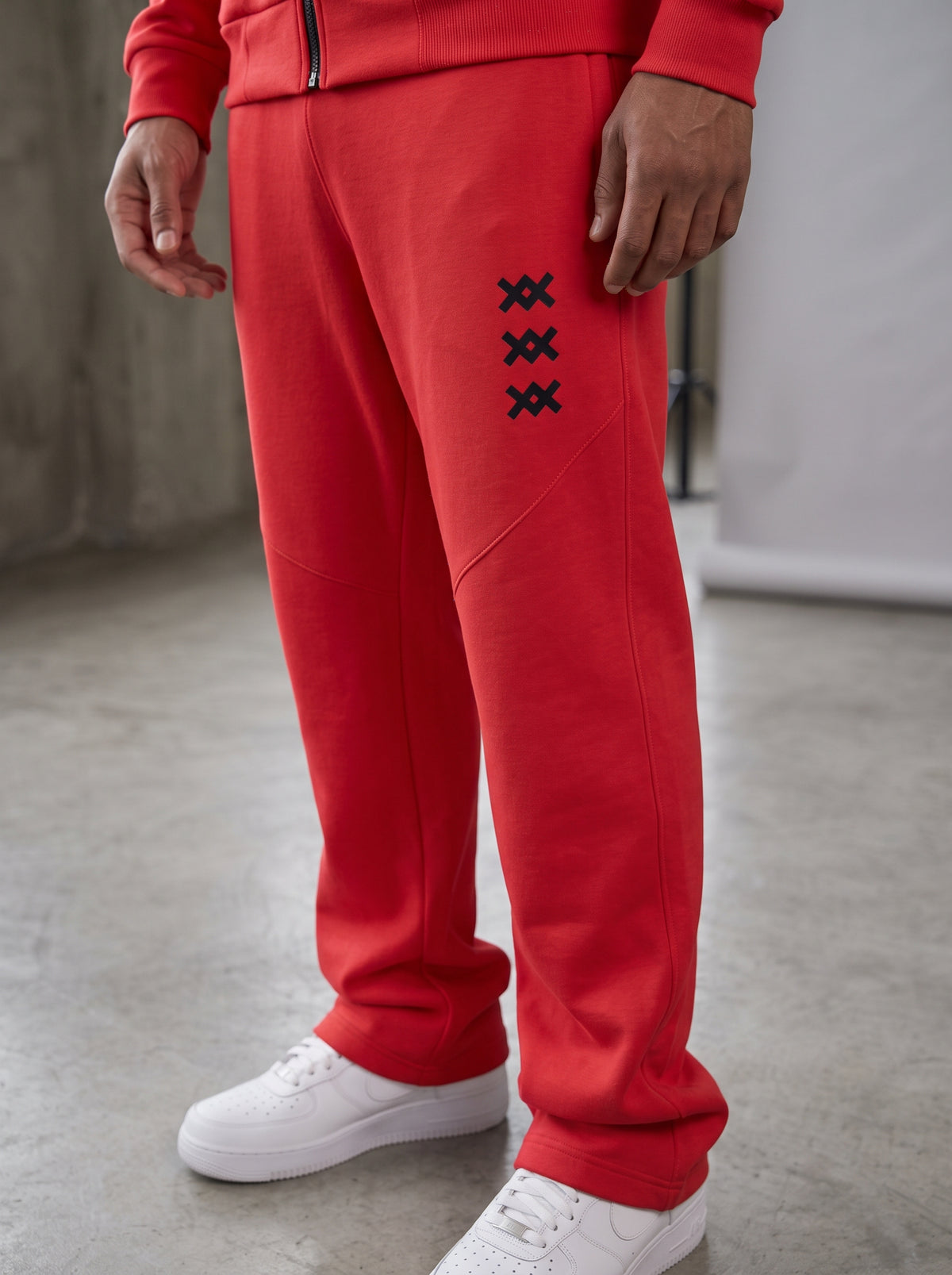 Pantalón del tracksuit AMV rojo de pierna recta con tres logos AMV en el muslo
