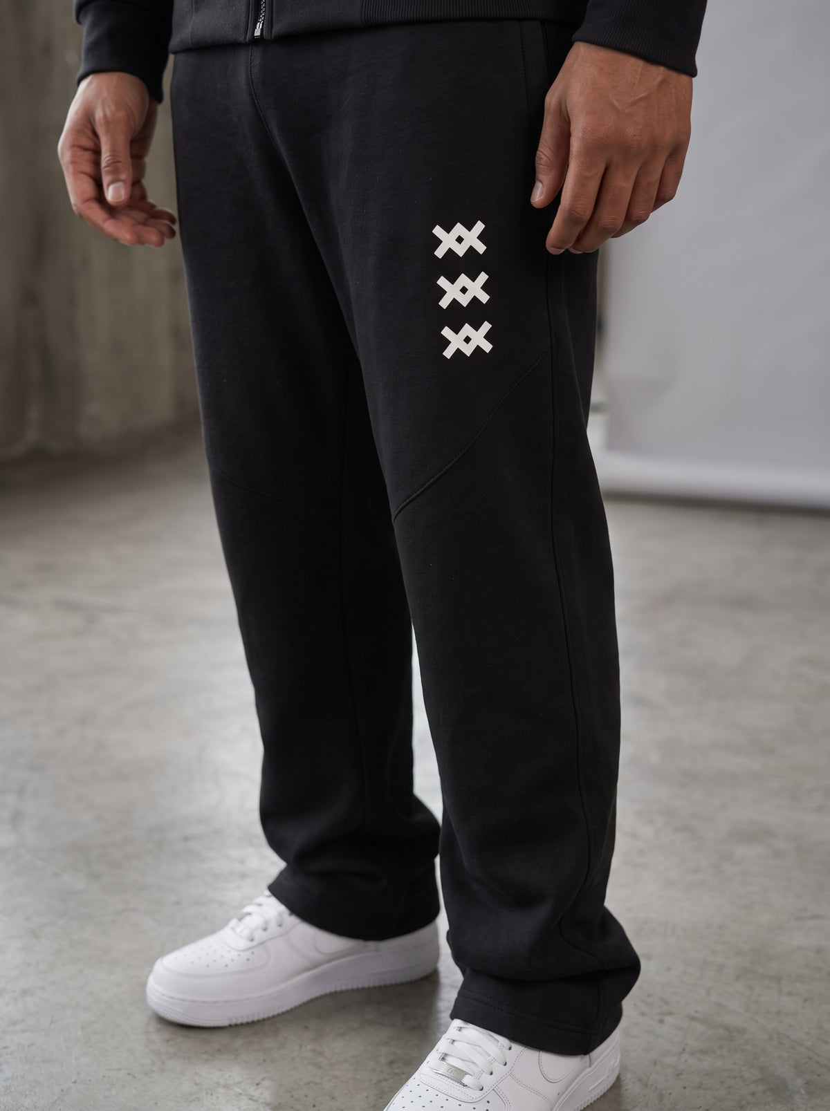 Tracksuit AMV negro con logos AMV blancos, vista en modelo